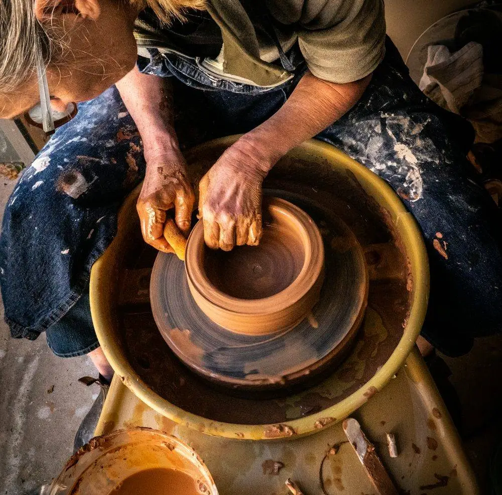 Potter shaping clay on a wheel