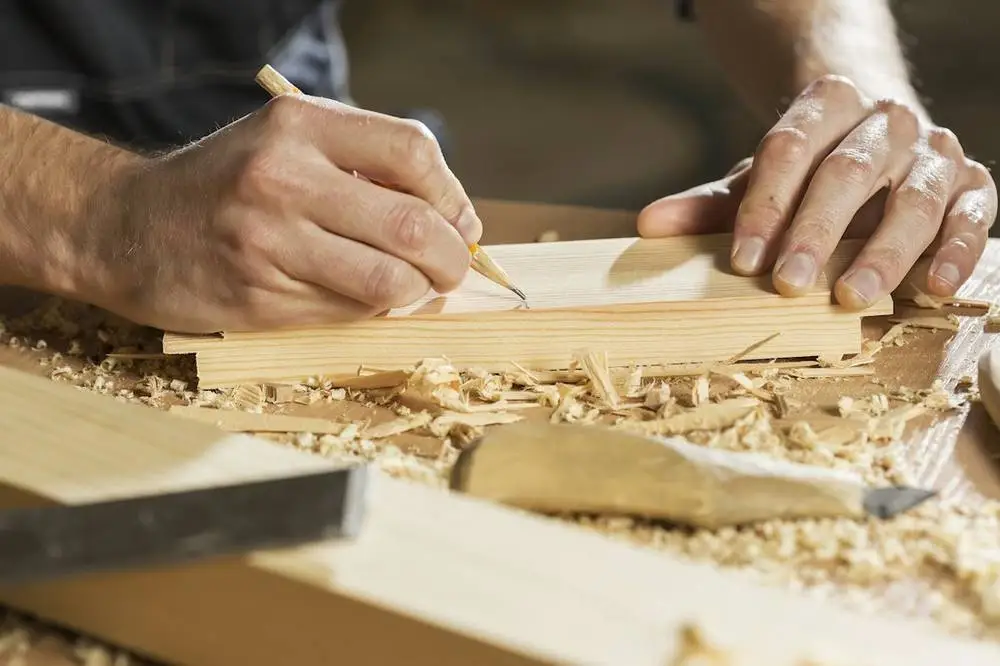Joiner marking timber in a workshop